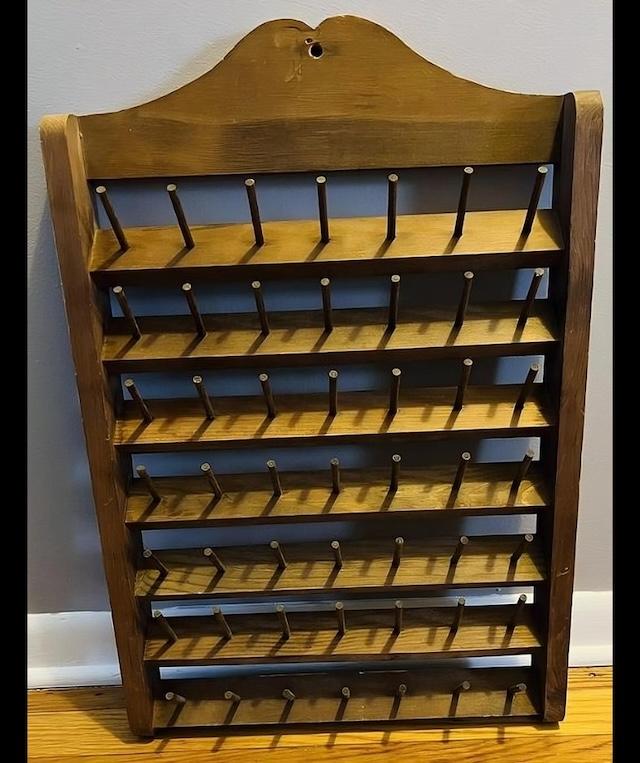 A beautiful vintage wooden thread spool holder, showcasing its classic craftsmanship, ideal for holding spools of various sizes.